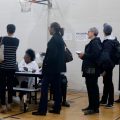People stand in line at a Detroit polling place during Michigan's March 10 presidential primary. Because of the pandemic, the state's top election official is sending absentee ballot applications to every registered voter for the fall election.