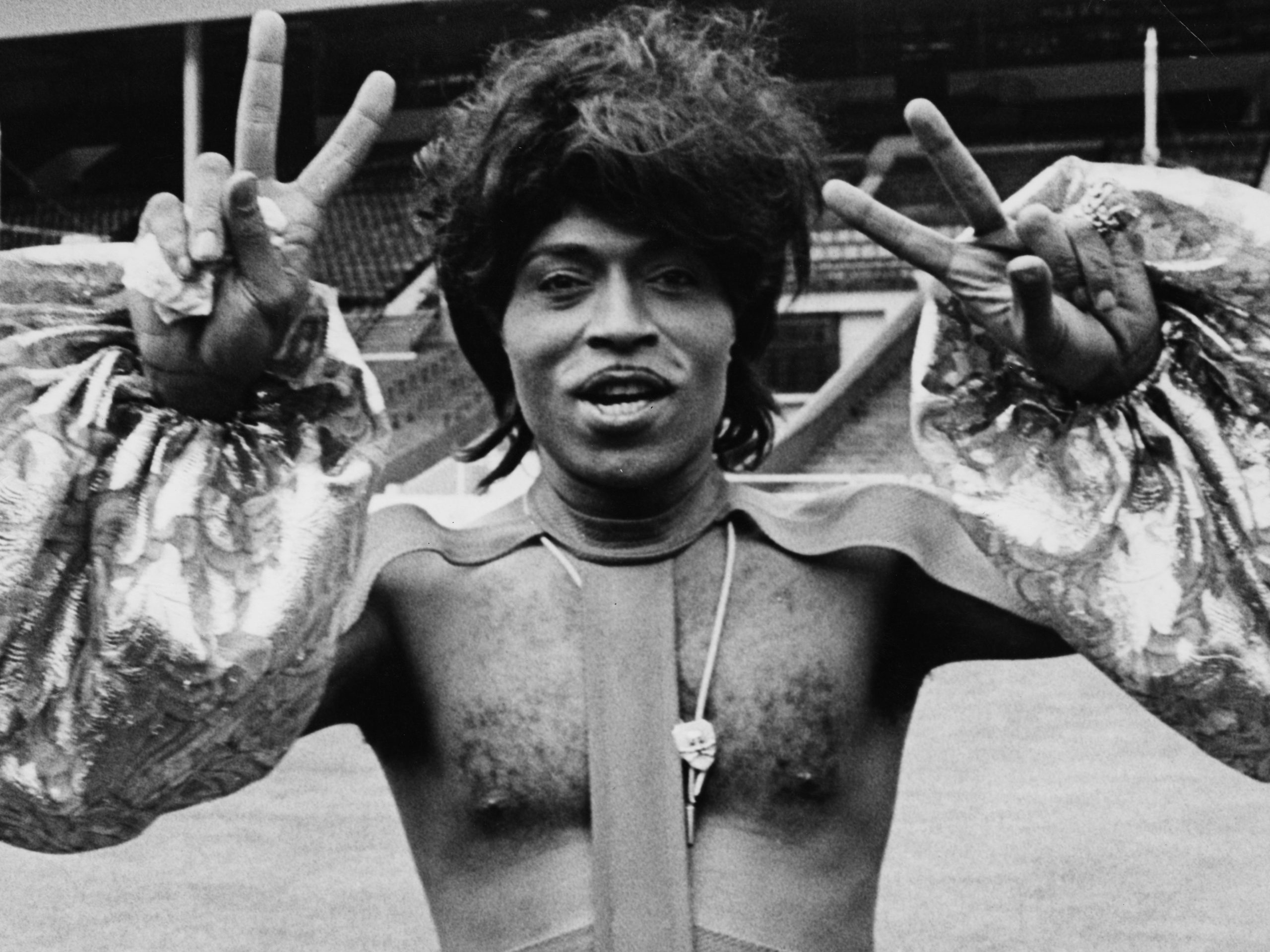 Singer Little Richard making peace sign and wearing an outlandish outfit as he prepares to perform at Wembley Stadium, 1972. (Photo by Rosemary Matthews/Keystone Features/Getty Images)