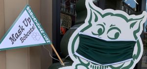 A cardboard cutout of Rufus Bobcat wearing a mask outside of College Bookstore in uptown Athens.