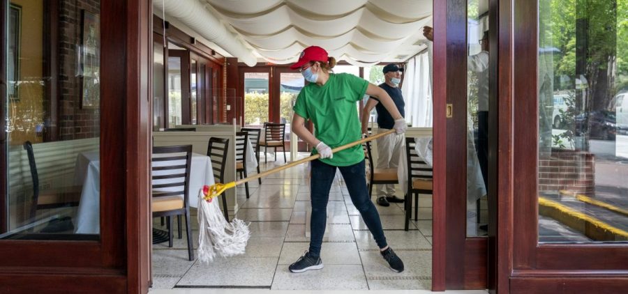 A cafe employee in Washington, D.C., cleans in preparation for reopening.