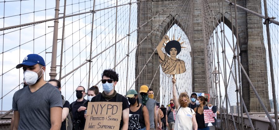 Protesters and activists walk across the Brooklyn Bridge Saturday in New York. Cities saw some of their biggest gatherings of the past two weeks on Saturday.