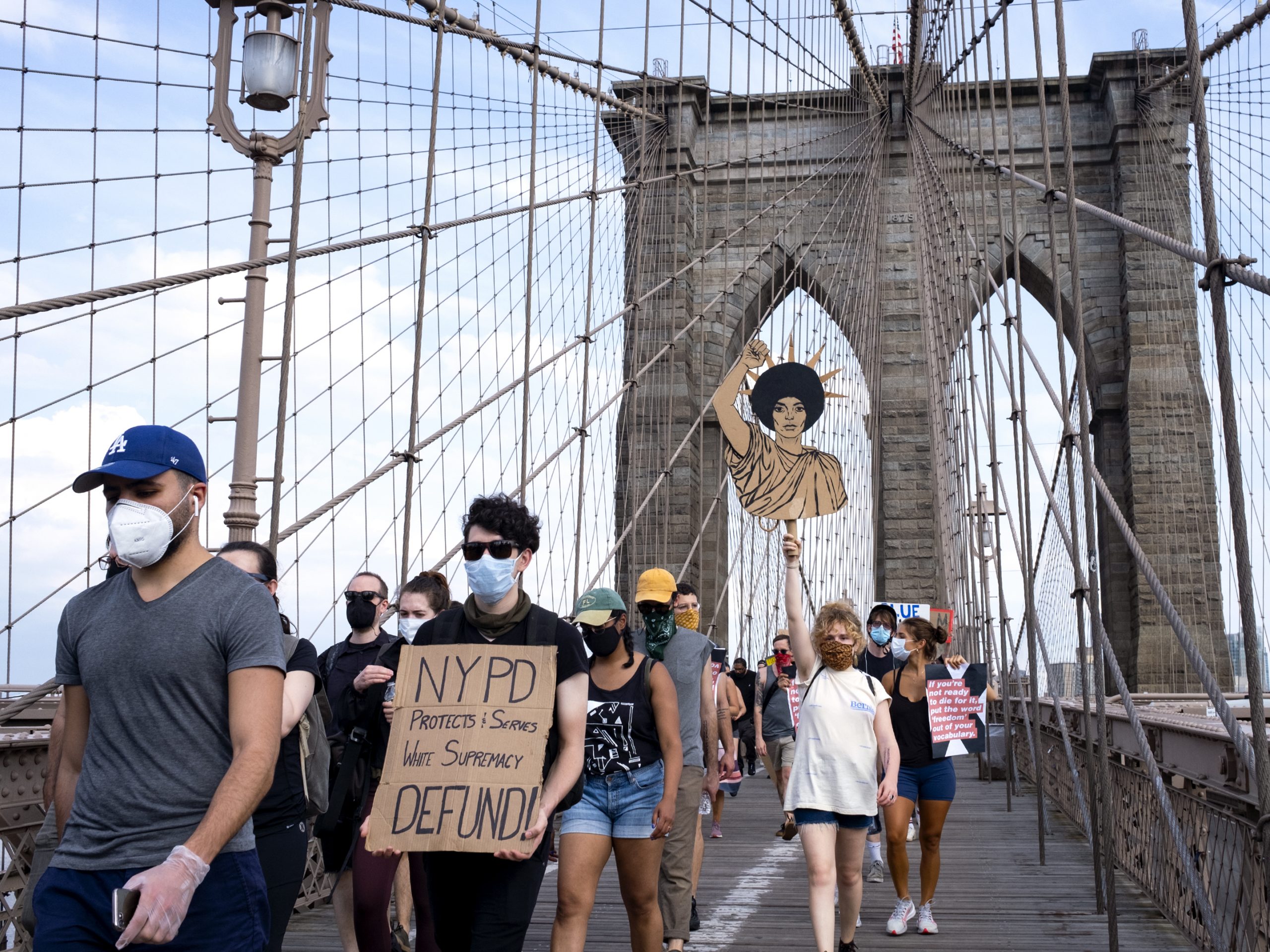 Protesters and activists walk across the Brooklyn Bridge Saturday in New York. Cities saw some of their biggest gatherings of the past two weeks on Saturday.