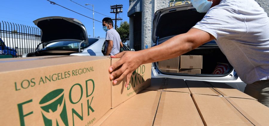 Boxes of food are loaded on vehicles last month at the Los Angeles Regional Food Bank. The country has officially entered a recession amid the pandemic, the National Bureau of Economic Research said Monday.