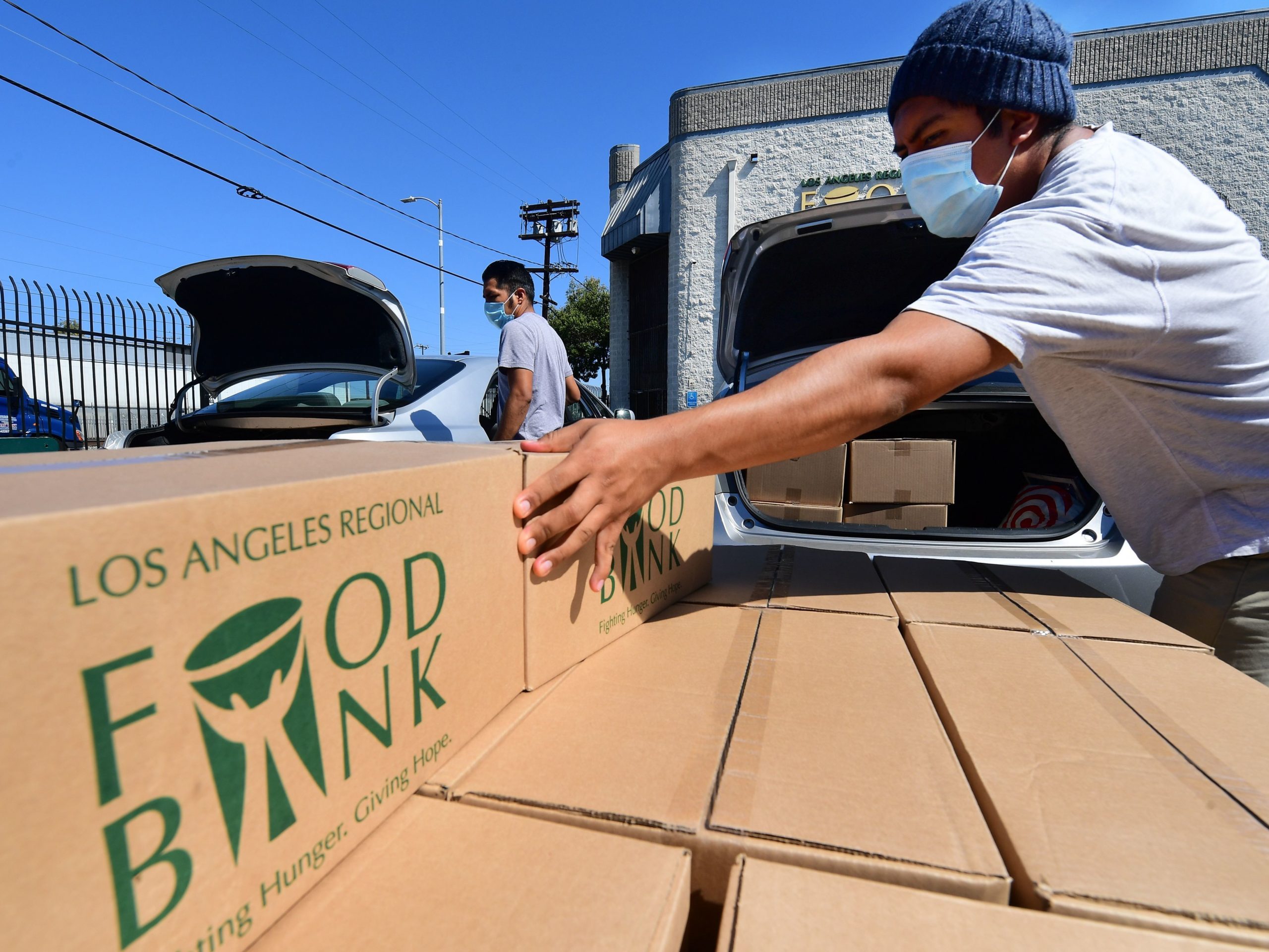 Boxes of food are loaded on vehicles last month at the Los Angeles Regional Food Bank. The country has officially entered a recession amid the pandemic, the National Bureau of Economic Research said Monday.
