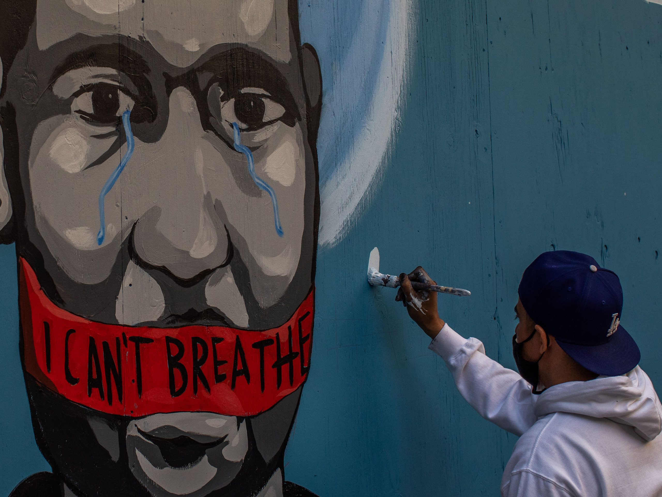 The artist Celos paints a mural in downtown Los Angeles on May 30, 2020 in protest against the killing of George Floyd by police in Minneapolis.