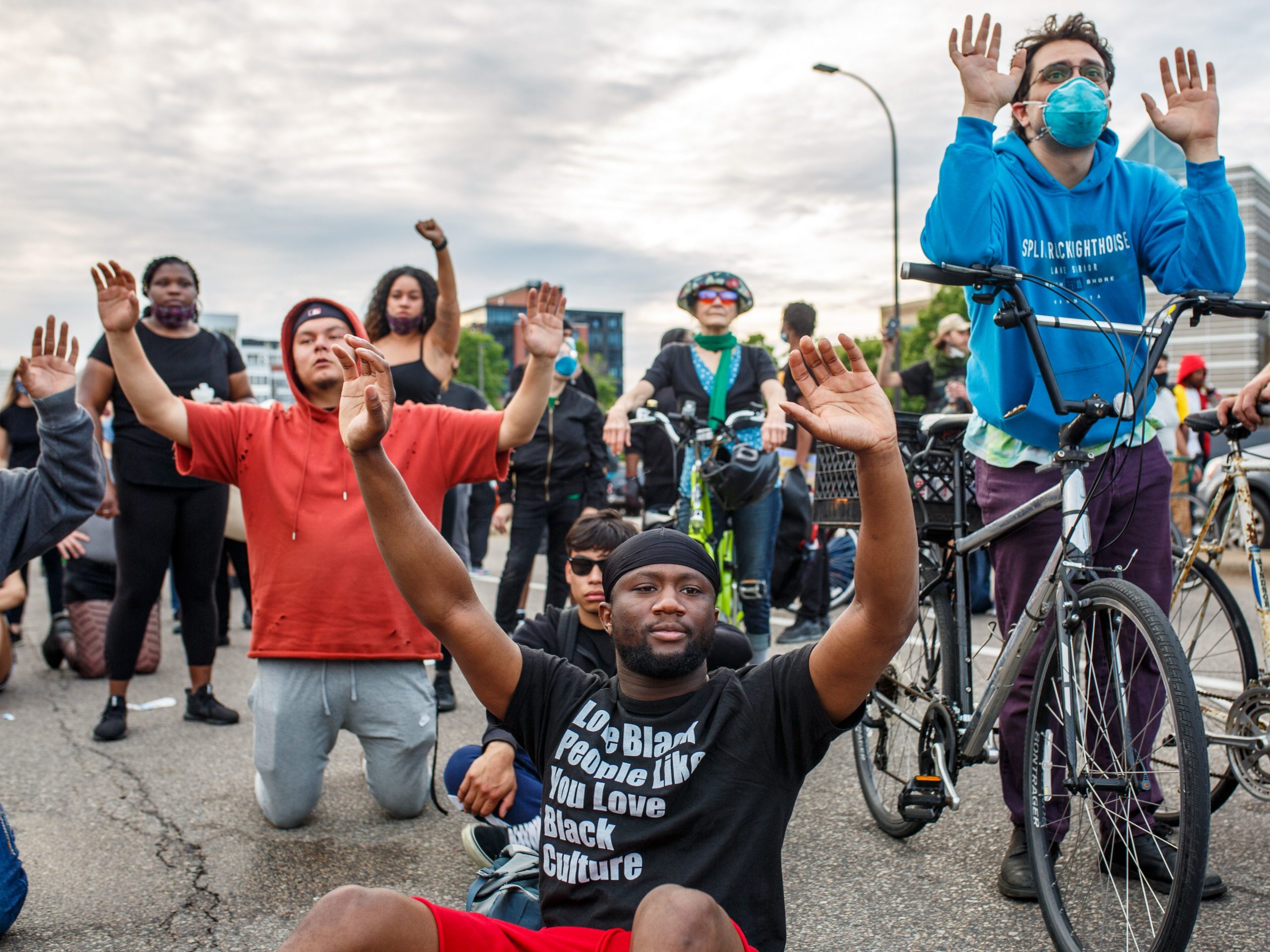Demonstrators kneel and raise their hands during a protest in Minneapolis on Sunday.