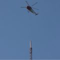 Helicopter hovering above old antenna