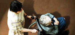 Nurse assists a nursing home resident in a wheelchair