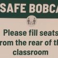 A sign inside one of Ohio University's academic buildings encouraging students to fill seats from the back of the room