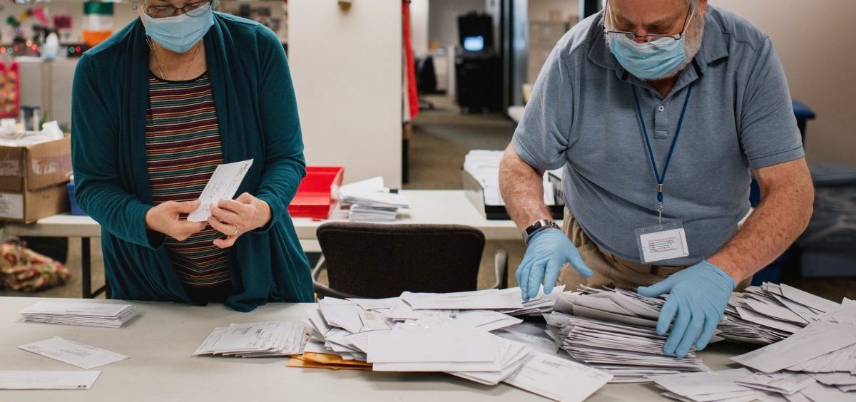 Andrea Lerner (left), and her husband, Ira Lerner, sift through the mail-in applications at the Voter Registration office in the Lehigh County Government Center in Allentown, Pa.