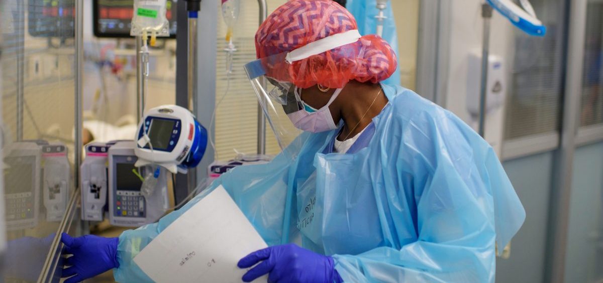 Niticia Mpanga, a registered respiratory therapist, checks on an ICU patient at Oakbend Medical Center in Richmond, Texas. The mortality rates from COVID-19 in ICUs have been decreasing worldwide, doctors say, at least partly because of recent advances in treatment.