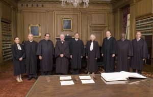 John Roberts (center) poses with the rest of the court after becoming chief justice, on Oct. 3, 2005. The other justices pictured are Ginsburg (from left), David Souter, Antonin Scalia, John Paul Stevens, Roberts, Sandra Day O'Connor, Anthony Kennedy, Clarence Thomas and Stephen Breyer.