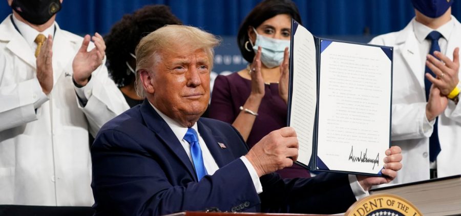 President Trump holds up an executive order after delivering remarks on health care in Charlotte, N.C., on Thursday.