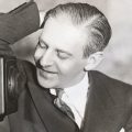 Young Winchell playfully leans against an NBC microphone.
