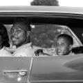 1960s SIDE VIEW OUTDOOR SMILING AFRICAN AMERICAN FAMILY FATHER MOTHER TWO SONS SITTING IN FOUR DOOR SEDAN AUTOMOBILE (Photo by H. Armstrong Roberts/ClassicStock/Getty Images)
