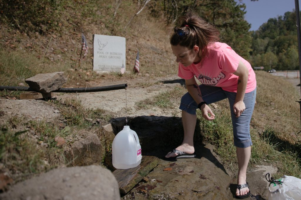 BarbiAnn Maynard drives 45 minutes from her home in Martin County, Kentucky, to a spring at the Mingo-Logan county line in West Virginia to fill containers with fresh water. 