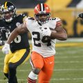 Cleveland Browns running back Nick Chubb (24) runs through a hole during the first half of an NFL wild-card playoff football game against the Pittsburgh Steelers, Sunday, Jan. 10, 2021, in Pittsburgh.