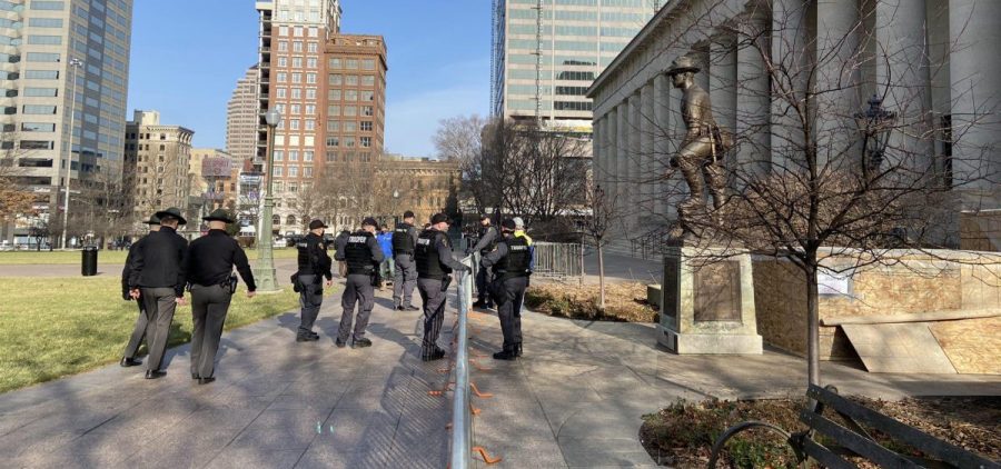 A group of Ohio State Highway Patrol troopers helps with putting up fencing around the closed-off entrance to the west side of the Ohio Statehouse, where protests are often held.