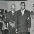 Leroy Carter (left) and Donald Jones, NAACP assistant field secretary (right), escort Sergeant Isaac Woodard (center) down an aisle. Likely taken while Woodard was on his speaking tour with the NAACP. 10/26/1946.