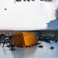 research tent near rocky shore and glacier