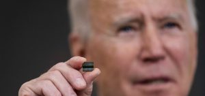 President Biden holds a semiconductor during remarks before signing an executive order on the economy at the White House on Feb. 24. On Monday, senior members of his team will meet with leaders across various industries to discuss a shortage of semiconductors.