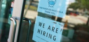 A store in Miami displays a "We are hiring" sign on March 5. U.S. employers added 916,000 jobs in March, the biggest number since August, amid an improving pandemic outlook and trillions of dollars in stimulus passed by Congress.
