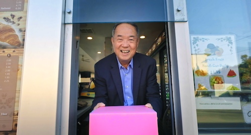 Ted Ngoy, The Donut King, nading donuts through a drive through window