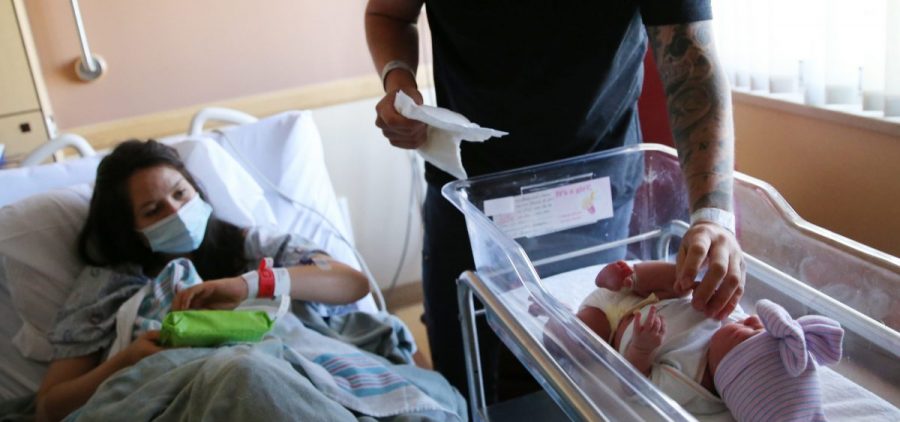 Matthew Carnes prepares to change diapers for his newborn daughter, Evelina Carnes, as his wife, Breanna Llamas, keeps watch in the postpartum unit at Providence St. Mary Medical Center in Apple Valley, Calif., in March. The U.S. has reported another record low in its birthrate.