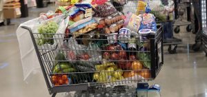 A shopper's cart is full in the checkout line at a ShopRite supermarket in April 2020 in Plainview, N.Y. A year later, prices for most goods have jumped, according to government data, as companies struggle to secure critical raw materials amid supply constraints.