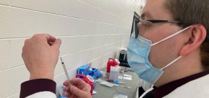 A technician from the Findlay College of Pharmacy fills a syringe with a dose of the Pfizer vaccine at a clinic in Reynoldsburg, February 2021.
