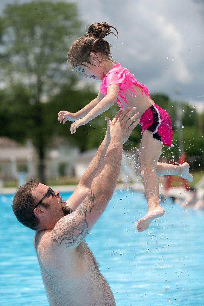 Zack Gorby tosses his daughter, Sophia Grace, 6, into the air on her birthday at the grand opening for the Crooksville Municipal Pool after it had been closed for two years, in Crooksville, Ohio, on Tuesday, June 8, 2021. "...I feel like it's a great thing," said Gorby when speaking about the pool re-opening. "Gives the kids something to do. Get them out of the house."