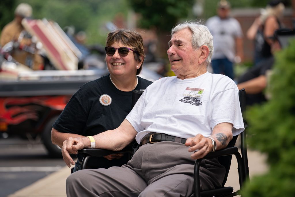 David Carter, right, 96, rests with his daughter Janis Duryea after a ride to Point Pleasant Ohio during the Valkyrie Riders Cruiser Club meetup in Athens, Ohio, on Tuesday, June 15, 2021. “I had rheumatic fever when I was in the Navy,” said Carter. “The doctor told me I would live to about 40, so I always say, if you’re not living on the edge, you’re taking up too much space.” [Joseph Scheller | WOUB]