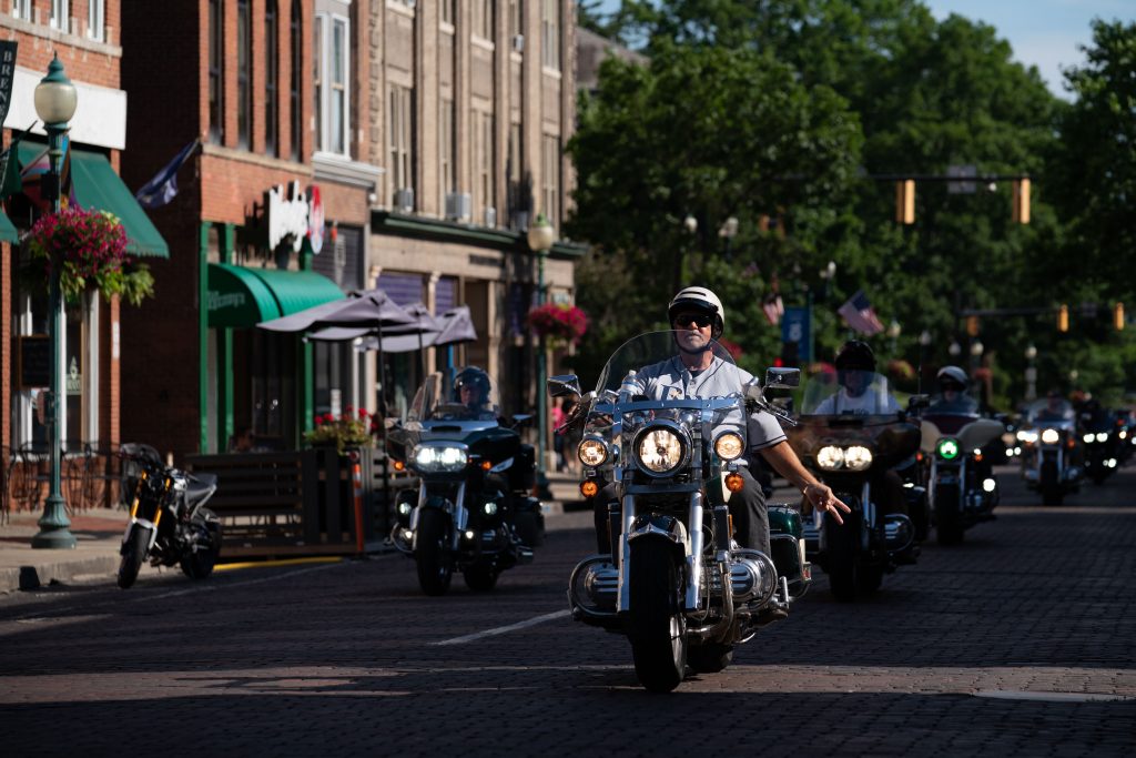 Jeff Brosseau, a Florida native who's been a member of the Valkyrie Riders Cruiser Club for a year, rides down Court Street prior on the way to a block party, in Athens, Ohio, on Tuesday, June 15, 2021. "I seen the motorcycle going down the road one day and I said I'm gonna' buy one of those," said Brosseau on how introduction to the motorcycle and club. "It started as a search for the bike and then I ended up finding the VRCC. And you know, the group just loves to ride and help each other out." [Joseph Scheller | WOUB]