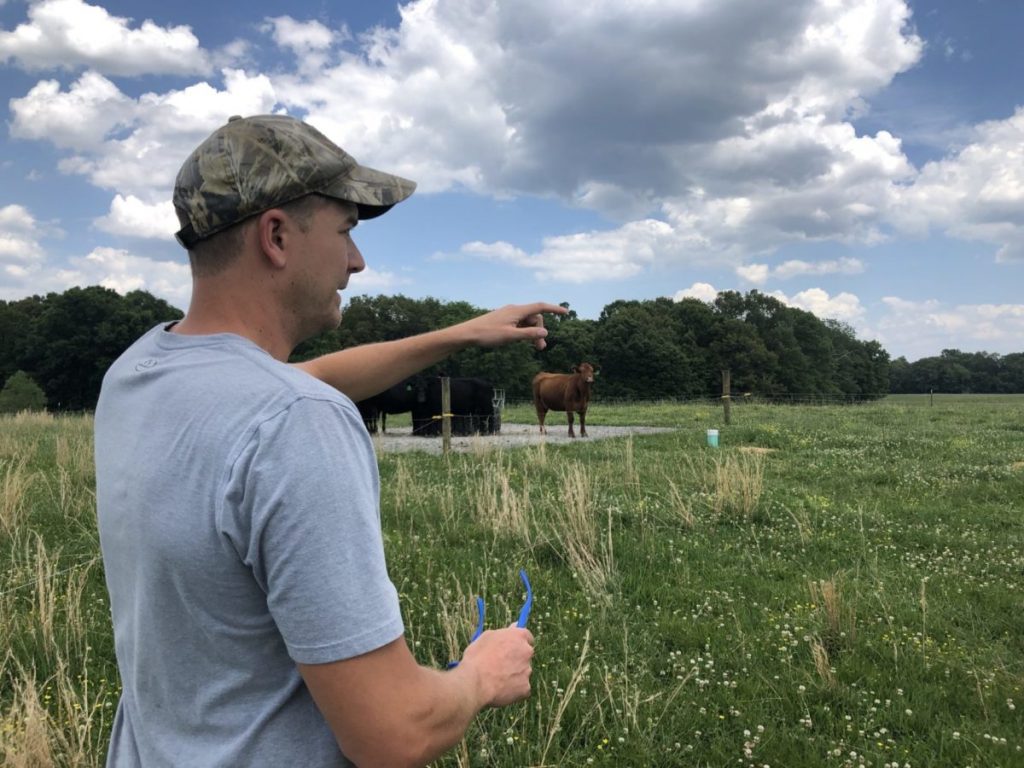 Cattle farmer Blake Munger points out some of the wired fencing on his farm in Calloway County, Kentucky.