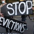 Housing activists erect a sign in front of Massachusetts Gov. Charlie Baker's house in Swampscott, Mass. on Oct. 14, 2020. The Centers for Disease Control and Prevention has extended a moratorium on evictions until the end of July.