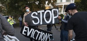 Housing activists erect a sign in Swampscott, Mass. A federal freeze on most evictions is set to expire soon. The moratorium, put in place by the Centers for Disease Control and Prevention in September, was the only tool keeping millions of tenants in their homes.