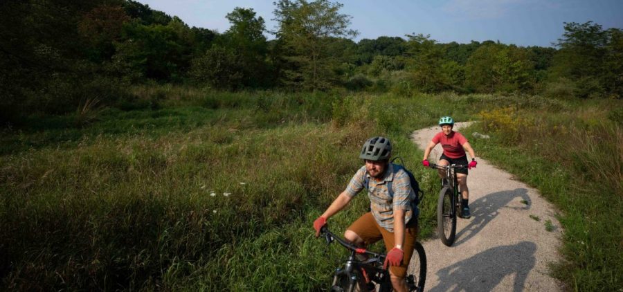 Meredith Erlewine, right, and Joe Crowley, both instructors with the Athens Co. Cougarbats Mountain Bike Team, ride through the beginning portions of the Baileys Trail System, in Chauncey, Ohio, on Saturday, Aug. 7, 2021.
