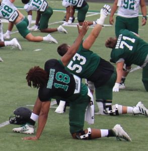 Ohio fifth year quarterback Armani Rogers stretches his arms prior to the Bobcats' first fall scrimmage on August 14, 2021 [Jack Demmler | WOUB]