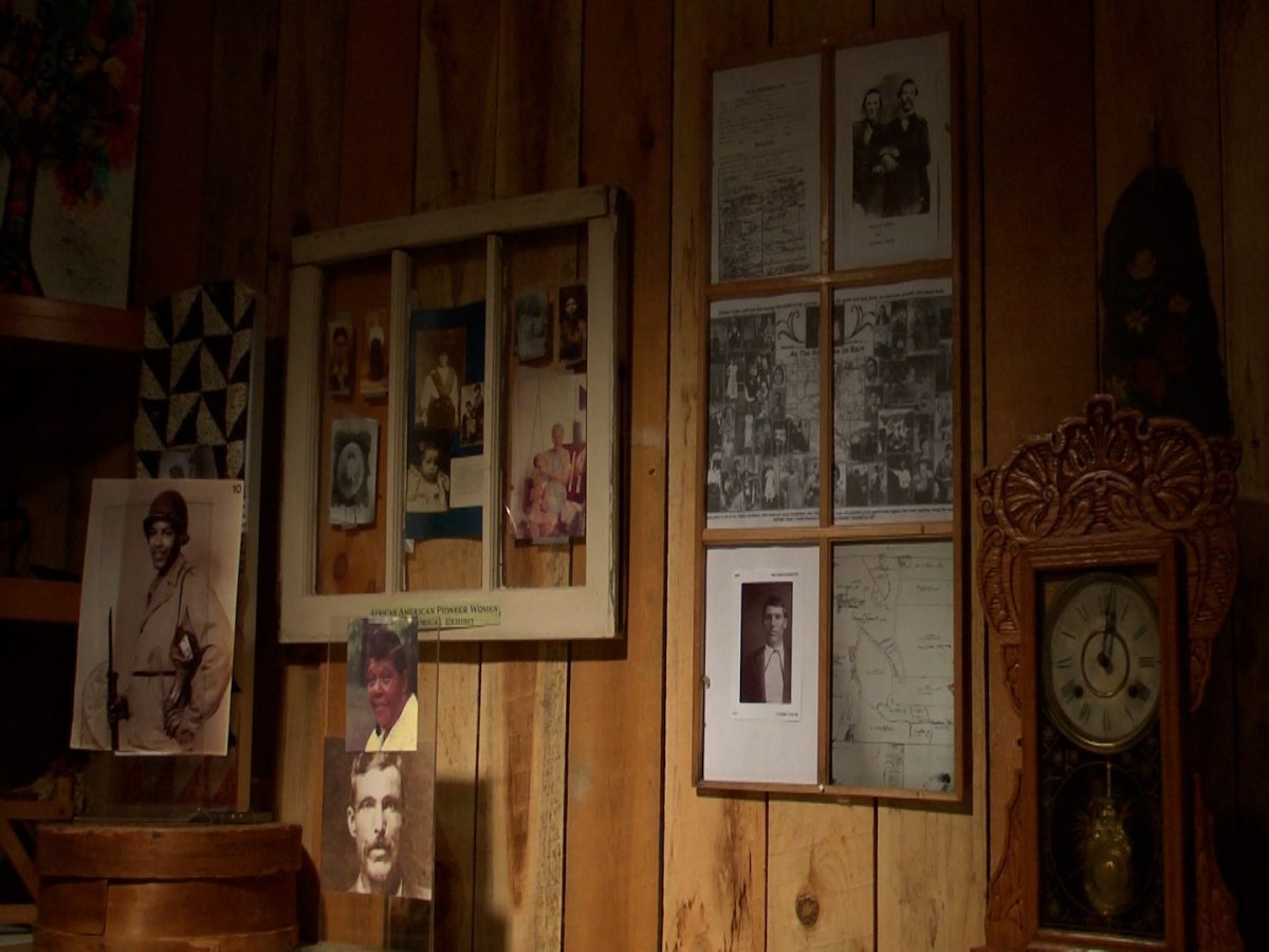 Framed photos of Butcher Family sit against wooden wall.