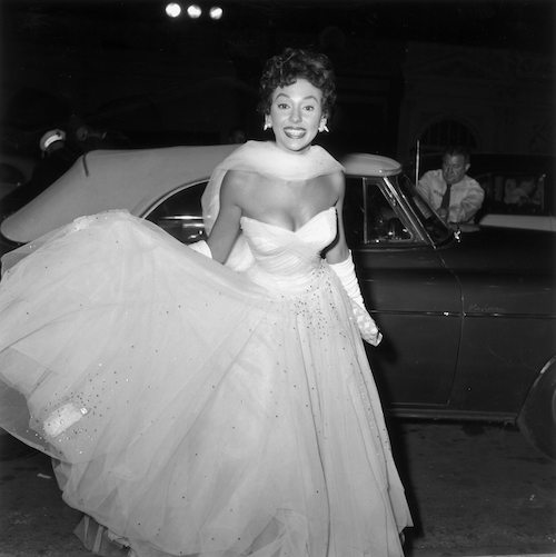 Rita Moreno in Cocktail Dress in front of Car.