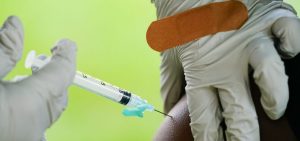 a health worker administers a dose of a Pfizer COVID-19 vaccine during a vaccination clinic at the Reading Area Community College in Reading, Pa
