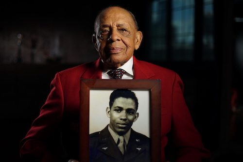 Retired Lt. Colonel Harold Brown, a member of World War II’s Tuskegee Airmen. holding photo of younger him in military dress