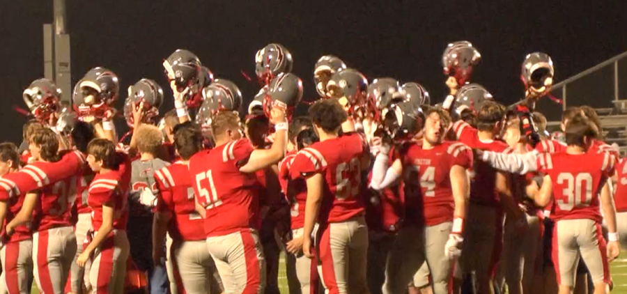 Piketon players celebrate by raising their helmets in a huddle