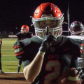 Meadowbrook player holds finger in front of mouth from end zone, making a whisper sign