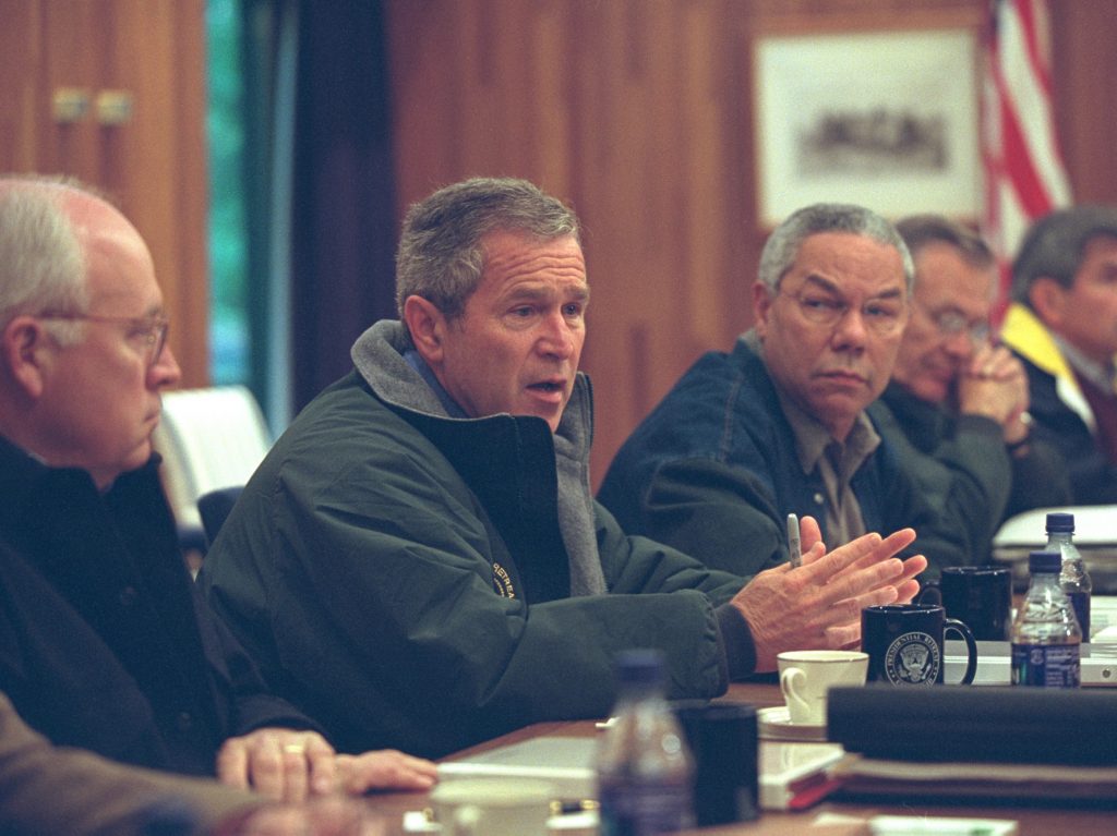 US President George W Bush (second right) meets with members of the National Security Council at Camp David, Thurmont, Maryland, September 15, 2001. Pictured are, from left, Vice President Dick Cheney, President Bush, Secretary of State Colin Powell, Secretary of Defense Donald Rumsfeld (1932 - 2021), and Deputy Secretary of Defense Paul Wolfowitz. 