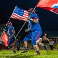 Fort Frye player running with american flag and team flag