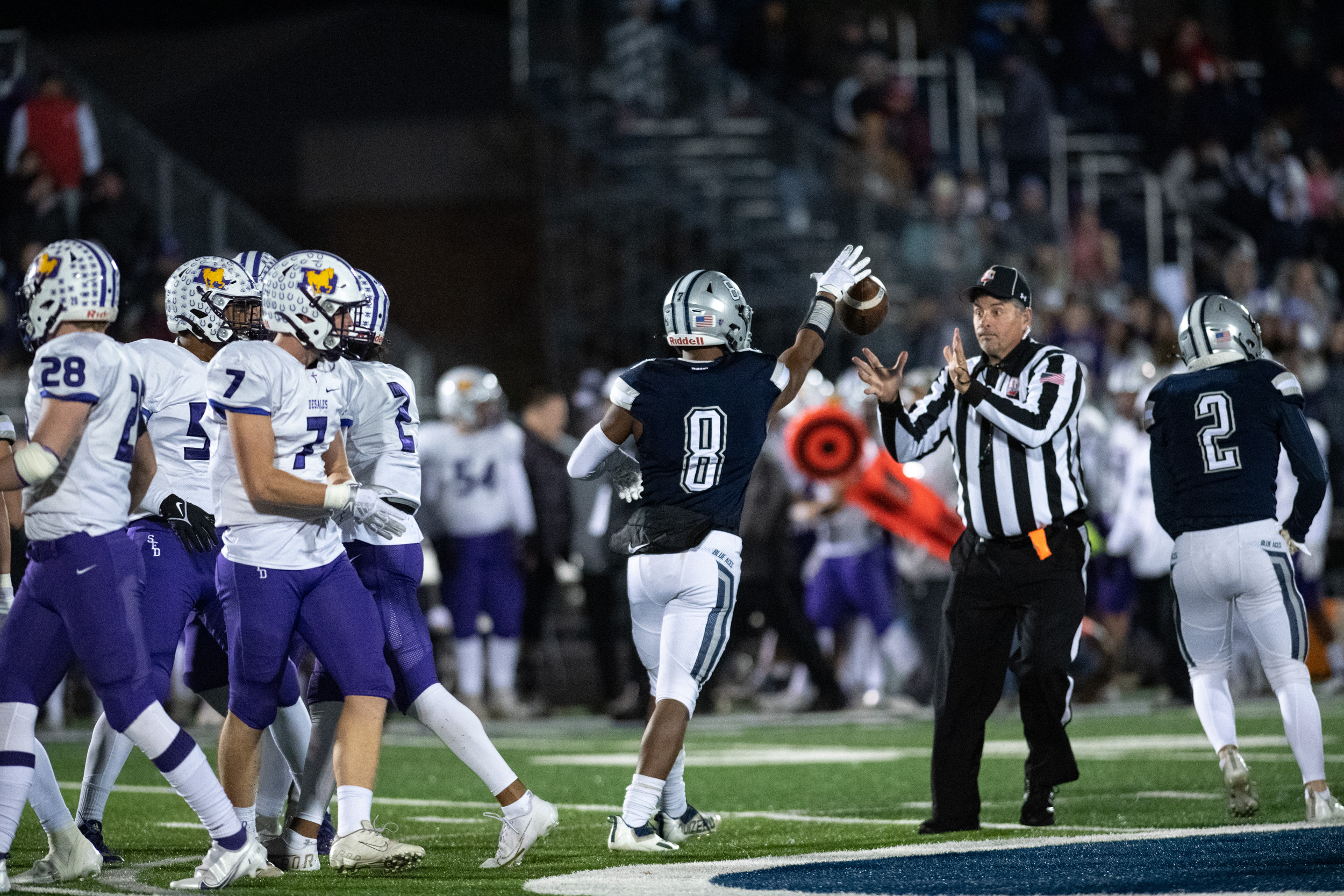 Devon Haley, number 8, of the Granville Blue Aces, tosses the football to a referee during the Blue Aces high school football playoff game against the St. Francis DeSales Stallions, in Granville, Ohio, on Friday, Nov. 5, 2021. The Blue Aces went on to win 19-12.