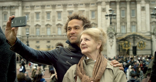 Older mom with adult son taking selfies at Buckingham Palace