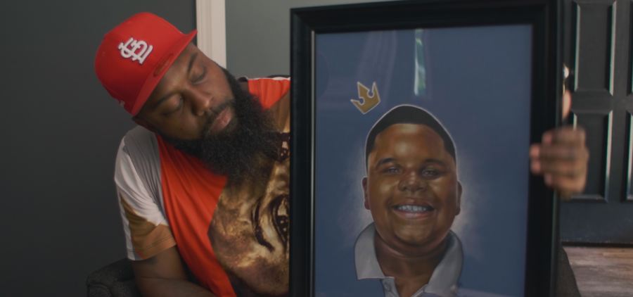 Michael Brown Sr. holds a painting of Jr. donated by an artist