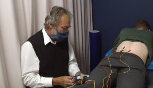 Photo by Joe Collins: Dr. Dan Black performs percutaneous electrical nerve stimulation on an OU Hockey player
